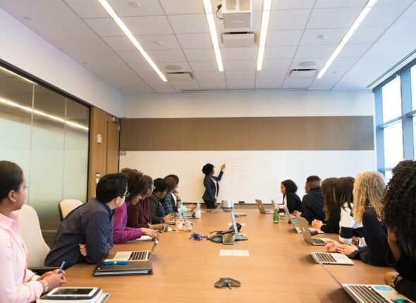 Membres d'un comité réunis autour d'une grande table de réunion, face à une présentation